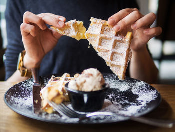 Midsection of person holding ice cream in plate