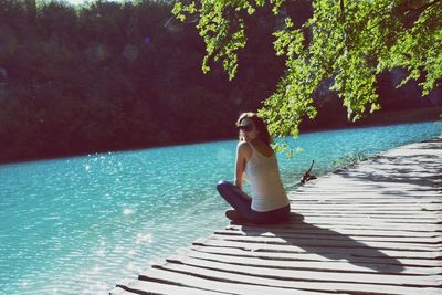 Side view of woman sitting on swimming pool