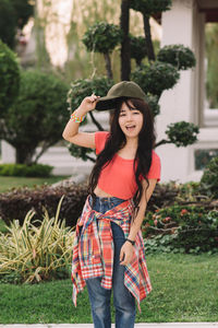 Portrait of young woman standing on field