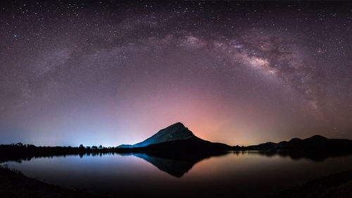 Scenic view of lake against sky at night