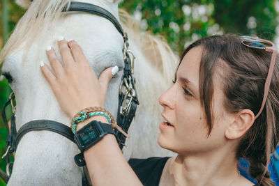 Woman embracing horse on field