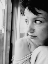 Close-up of thoughtful woman looking through window
