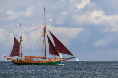 Sailboat sailing on sea against sky