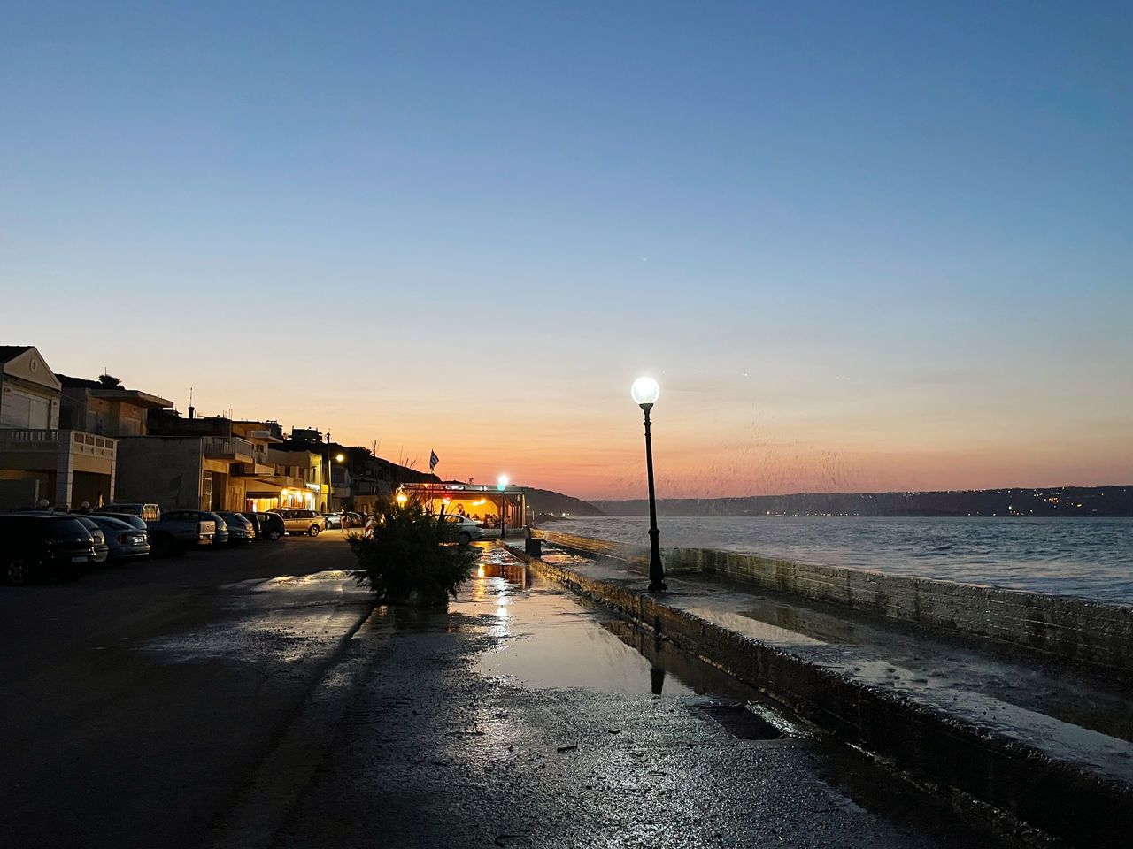 STREET BY SEA AGAINST SKY DURING SUNSET