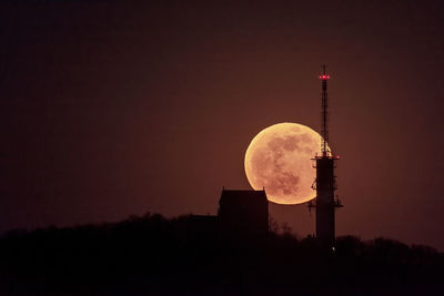 Silhouette tower against sky at night