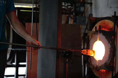 Cropped image of worker burning metal in factory