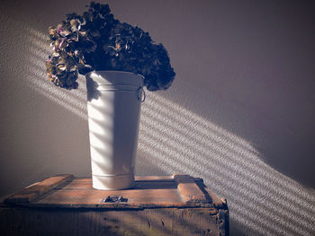 Close-up of white vase on table against wall