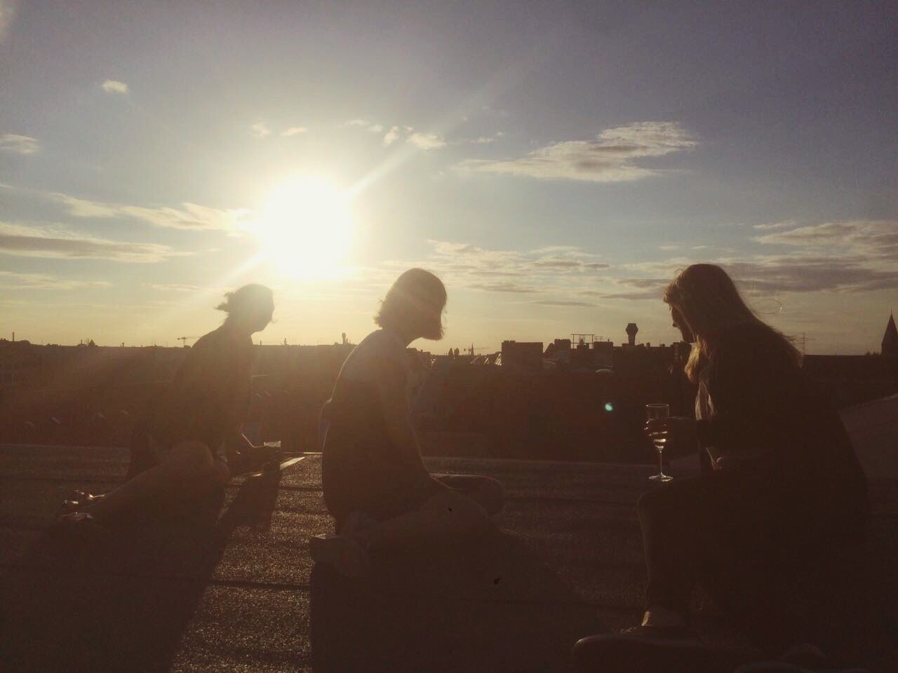 SILHOUETTE PEOPLE SITTING AGAINST SKY DURING SUNSET