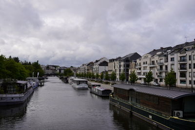 Panoramic view of river amidst buildings in city against sky