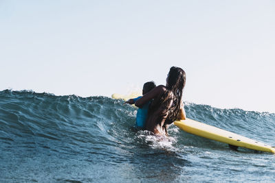 A surfer mother surfing with her son