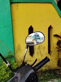 Close-up of bicycle against yellow wall