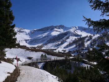 Scenic view of snowcapped mountains against clear blue sky