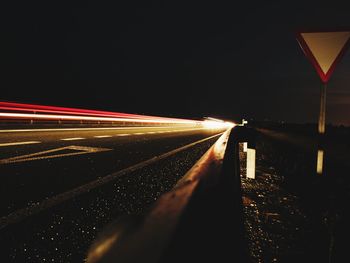 Light trails on road against sky at night