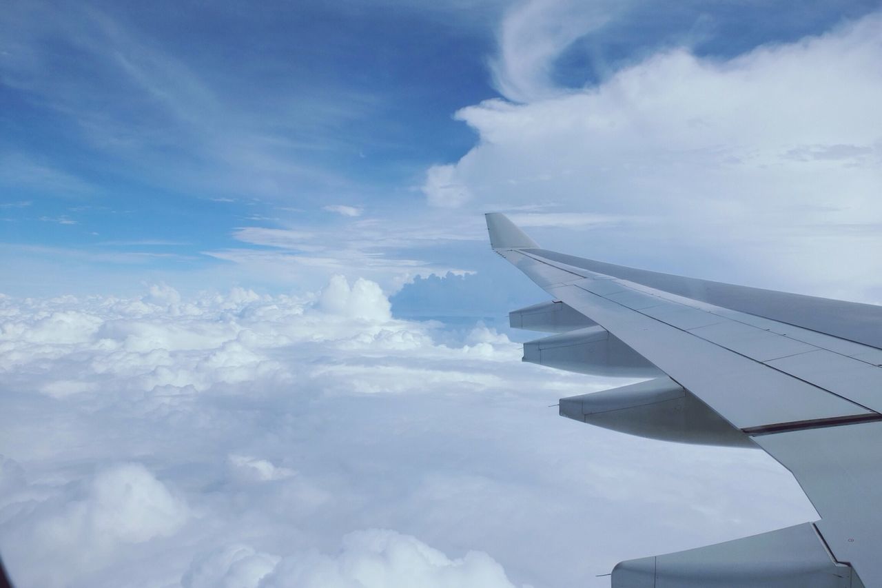 sky, airplane, cloud - sky, aircraft wing, air vehicle, flying, part of, cropped, cloud, beauty in nature, scenics, cloudy, transportation, nature, mode of transport, cloudscape, aerial view, white color, blue, day