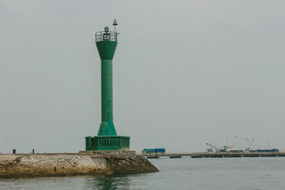 Tower in sea against clear sky