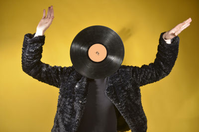 Woman with turntable standing against colored background