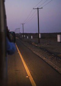 View of empty road along railway tracks