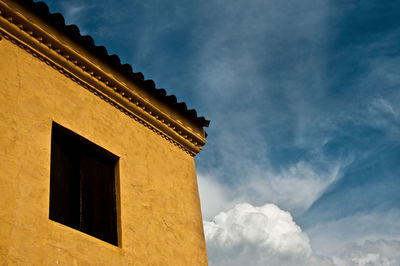 Low angle view of building against cloudy sky