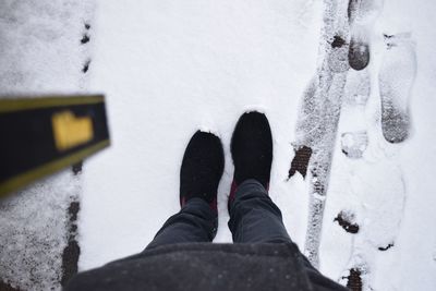 Low section of person standing on snow