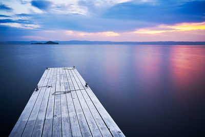 Pier over sea against sky during sunset