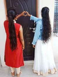Rear view of women standing in corridor