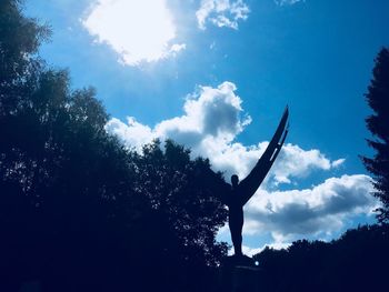 Low angle view of silhouette trees against blue sky