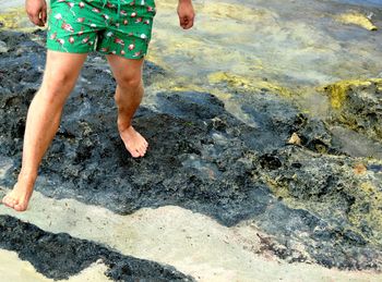 Low section of man standing on beach