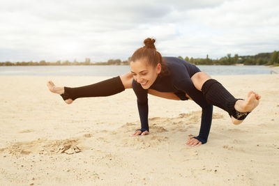 Full length of young woman sitting on beach