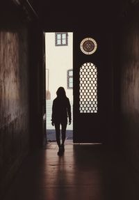 Rear view of silhouette woman walking in corridor