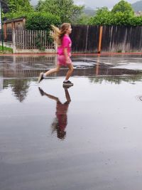 Full length of woman with reflection in water