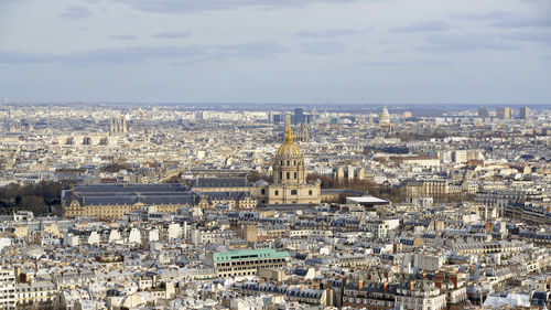 High angle view of city buildings against cloudy sky