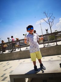 Full length of boy wearing sunglasses against sky