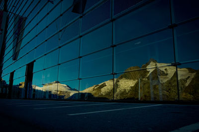 Snow covered mountains reflected in glass