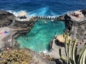 High angle view of people on pool by sea