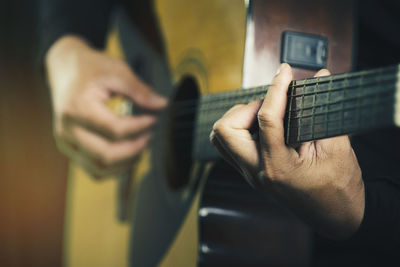 Midsection of man playing guitar