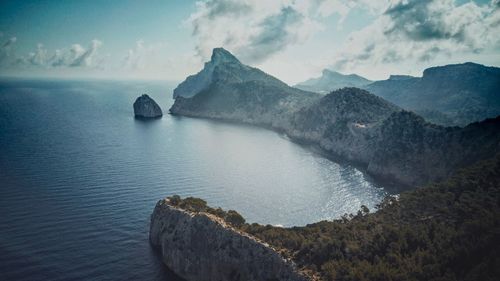 Scenic view of sea and mountains against sky