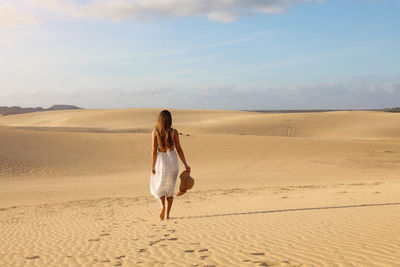 Rear view of woman on sand dune