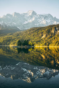 Scenic view of lake by mountains against sky