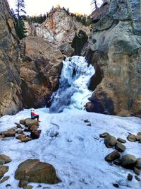 Scenic view of waterfall against mountain