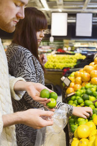 Young couple choosing fruits at supermarket