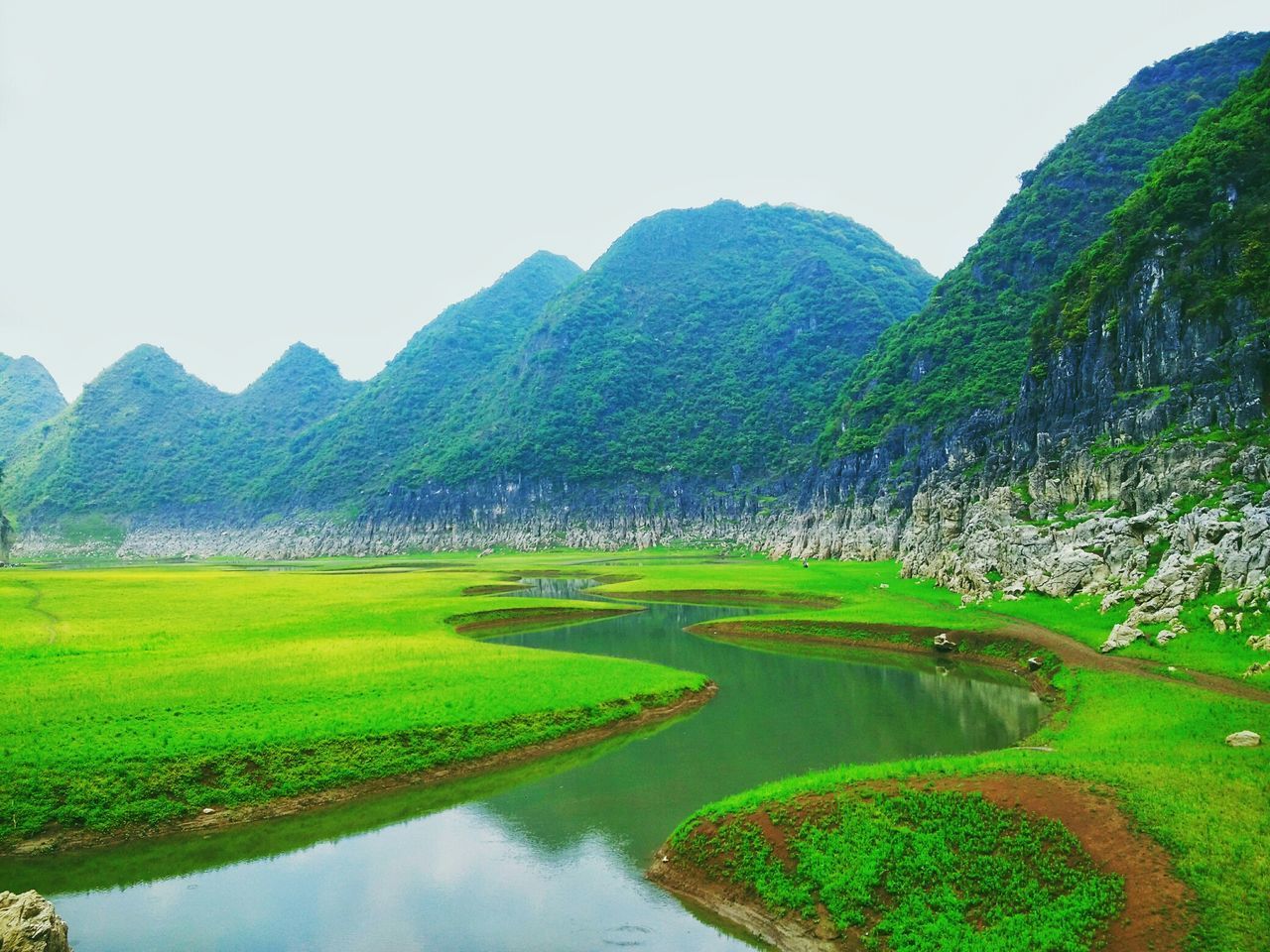 tranquil scene, tranquility, water, scenics, mountain, beauty in nature, reflection, green color, tree, nature, landscape, clear sky, lake, grass, idyllic, waterfront, river, green, growth, sky