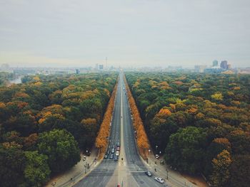 Road amidst trees against sky during autumn