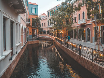 Canal by building in city