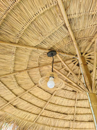 Low angle view of electric lamp hanging on roof