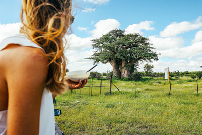 Female eating breakfast at green's baobab tree botswana makgadikgadi pans.
