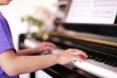 Midsection of person playing piano