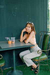 Portrait of smiling young woman sitting on chair