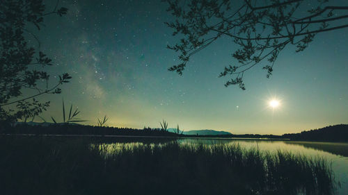 Scenic view of lake against sky at night