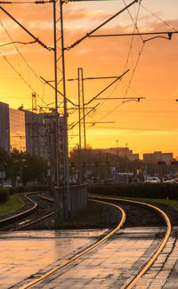 Railroad tracks against sky during sunset