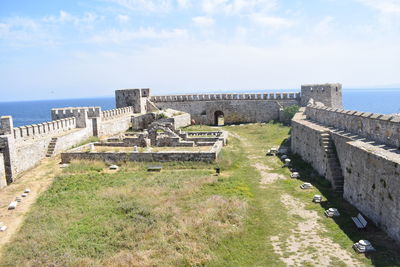 Built structure by sea against sky